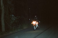 a person riding a motorcycle in the dark