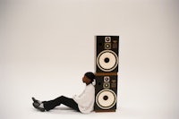 a person sitting on top of speakers