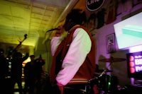 a man in a red jacket singing into a microphone