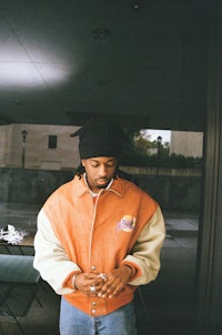 a man wearing an orange and white jacket